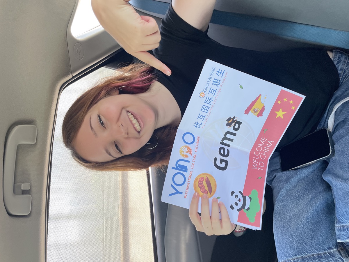 Gema smiling with her personalised Yohoo airport welcome board