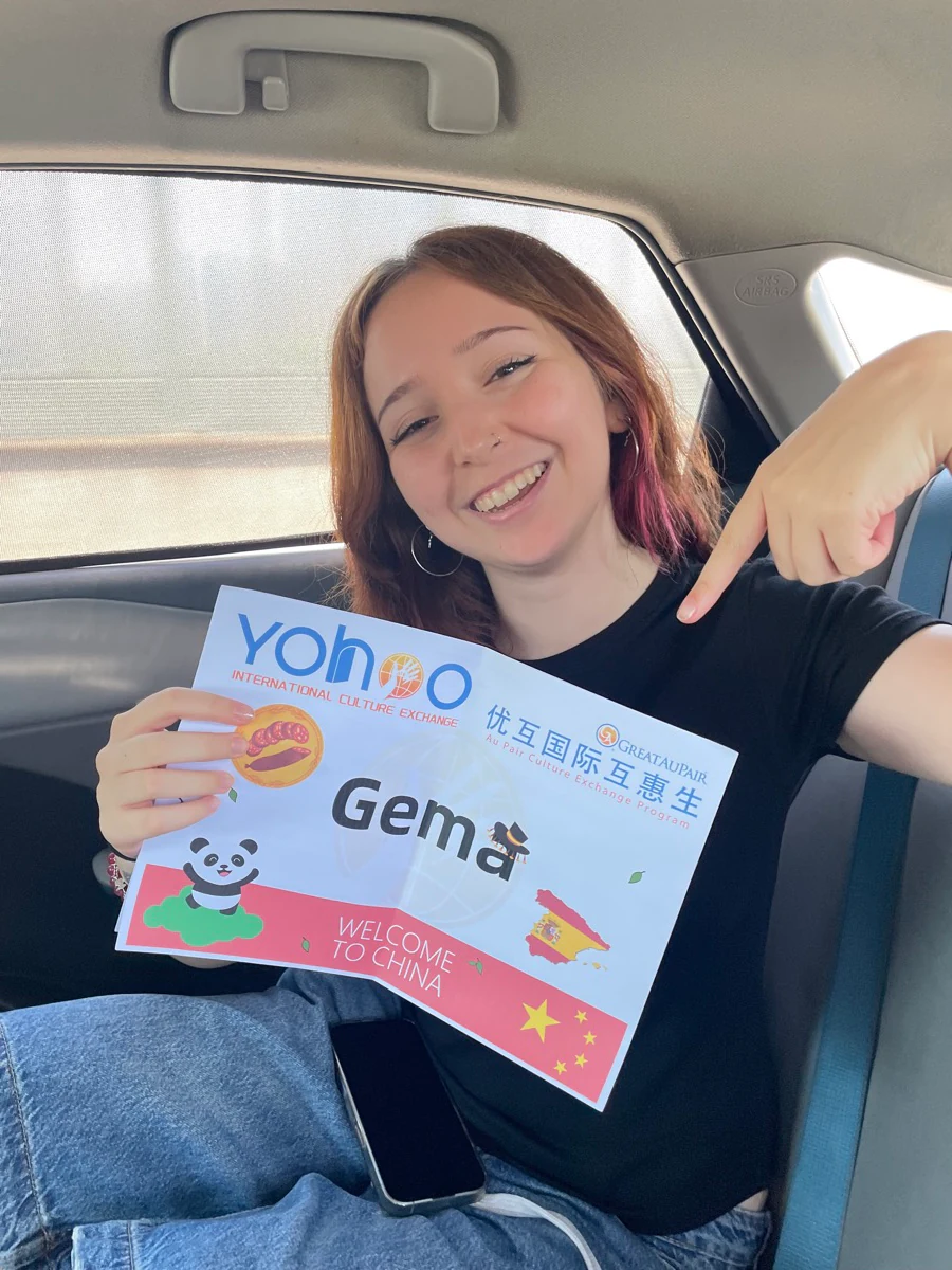 Gema smiling with her personalised Yohoo airport welcome board